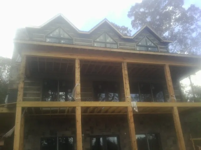 Dormers and porch framing on a large log home under construction — Roof Coating work by our crew in Aberdeen Proving Ground