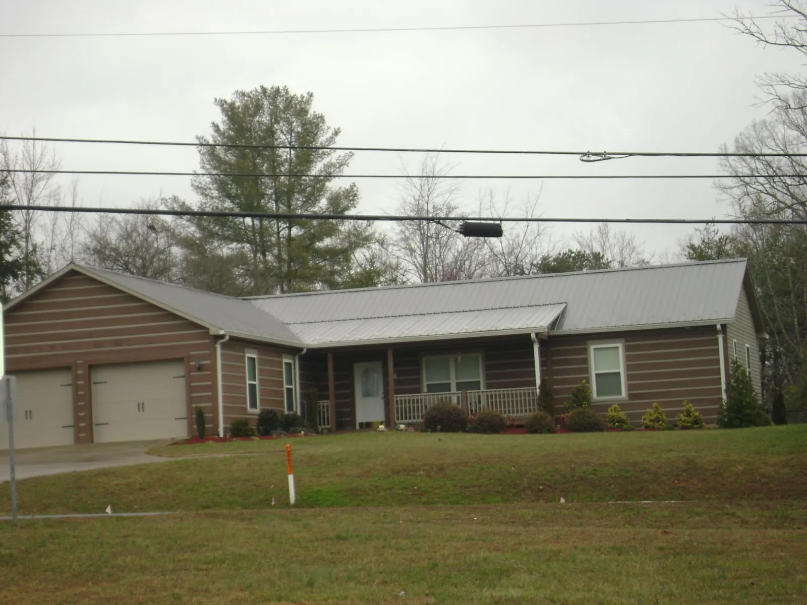 Gray metal roof on a log sided ranch home with a front porch in Aberdeen Proving Ground